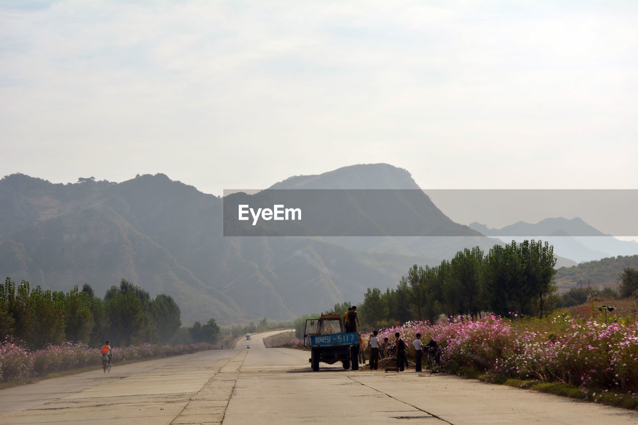 Road by mountains against sky