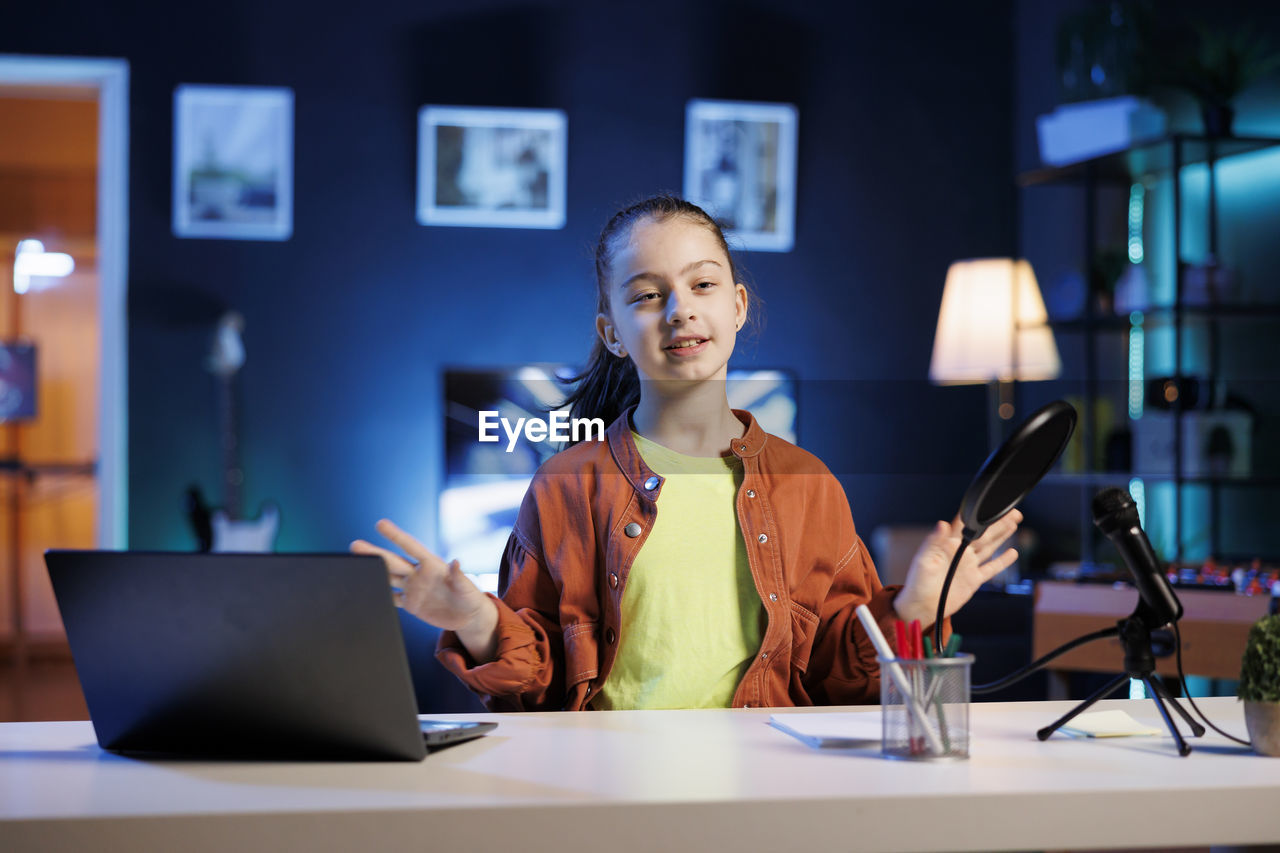 portrait of young woman using laptop at table