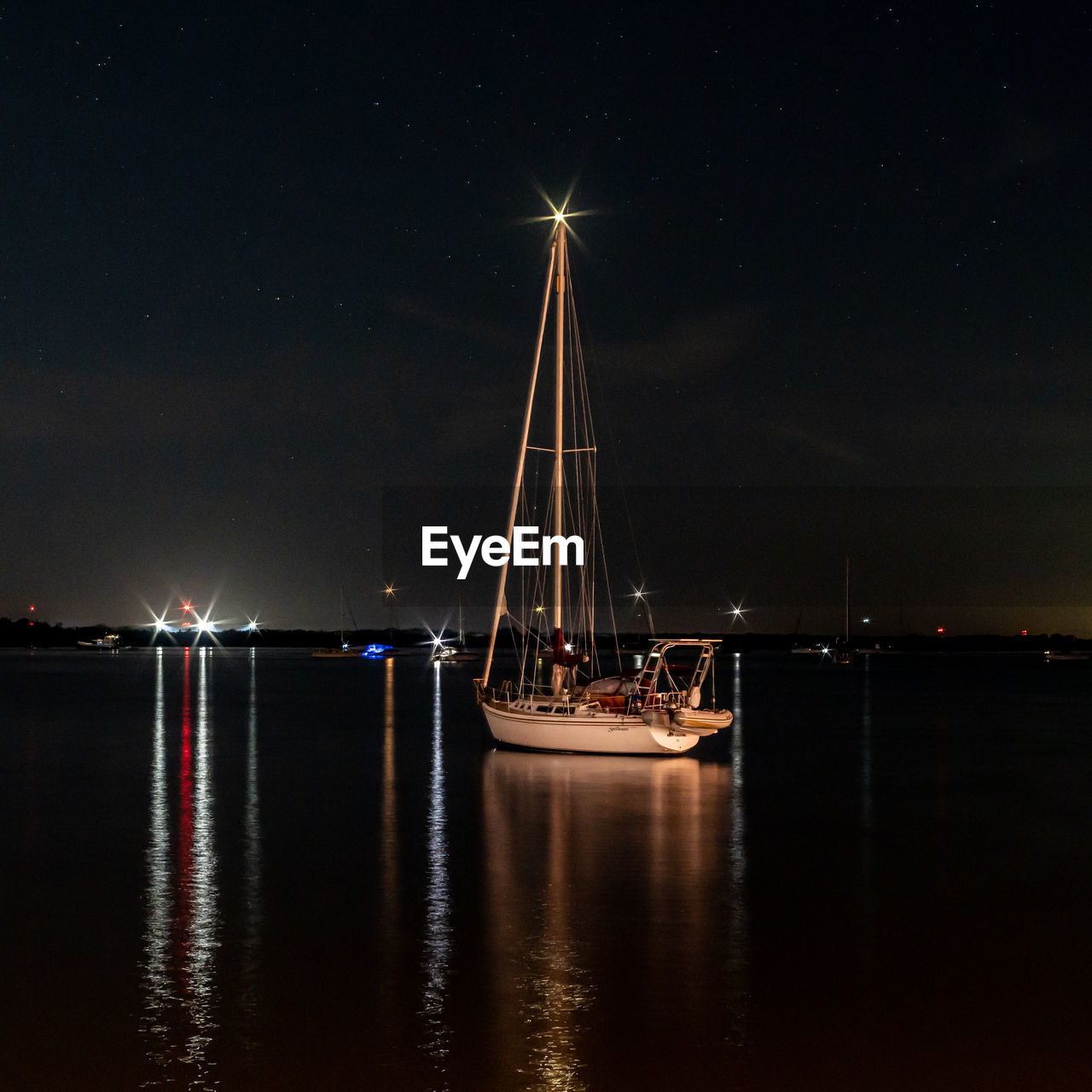 Sailboats in sea against sky at night