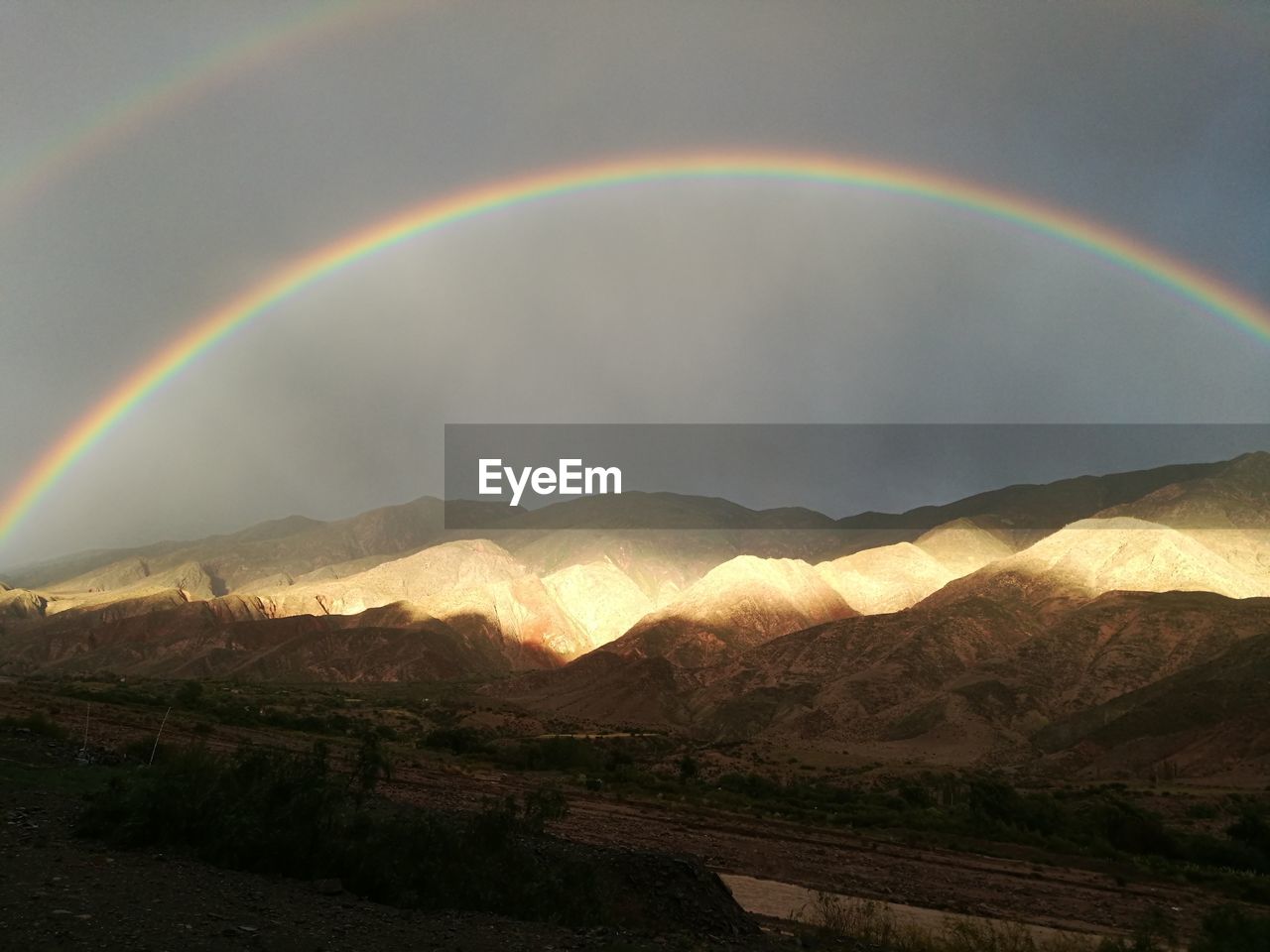 RAINBOW OVER MOUNTAIN AGAINST SKY