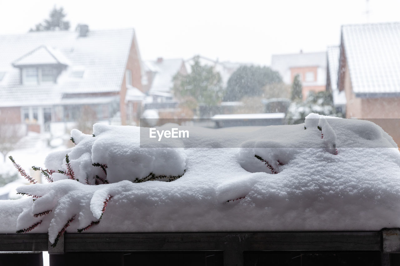 SNOW COVERED HOUSES AGAINST BUILDINGS