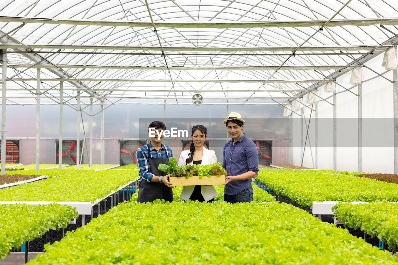 Portrait of woman standing in greenhouse