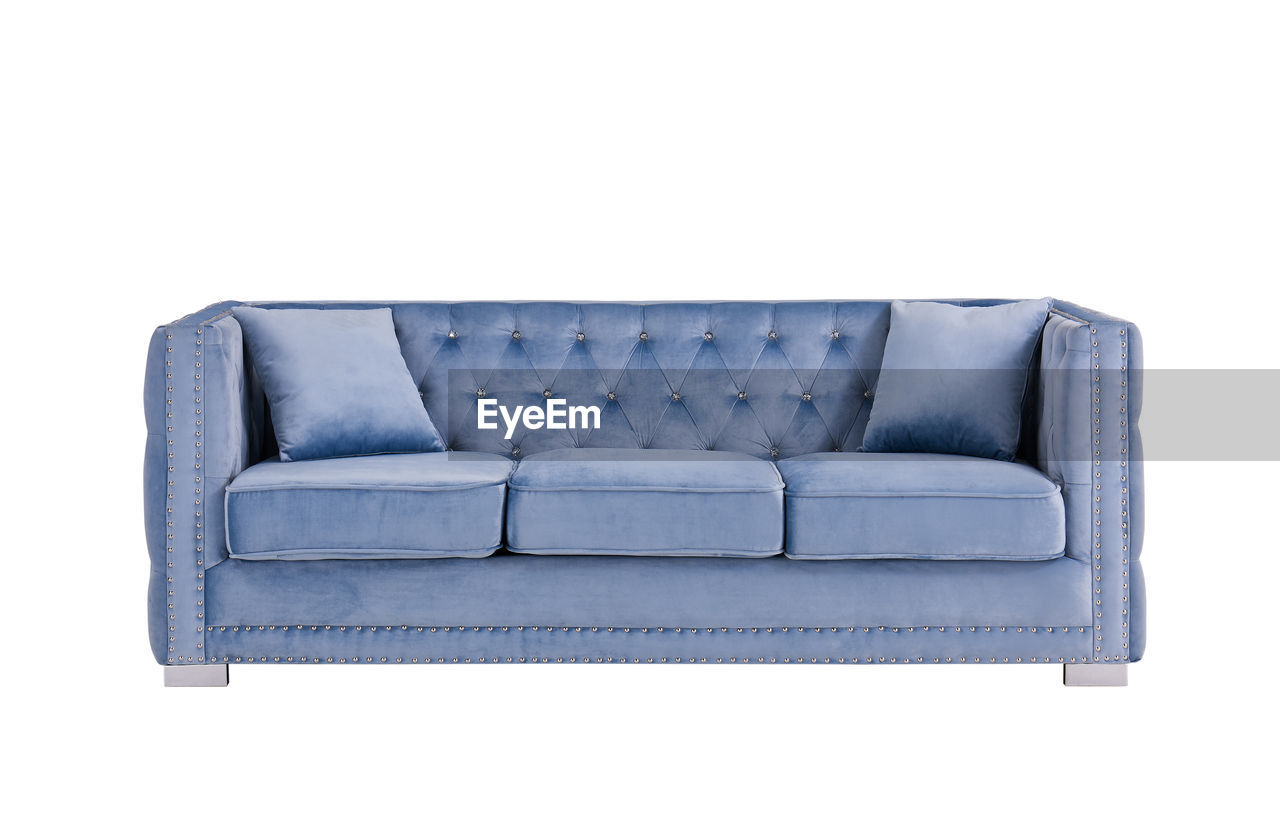 CLOSE-UP OF SOFA AGAINST BLUE BACKGROUND