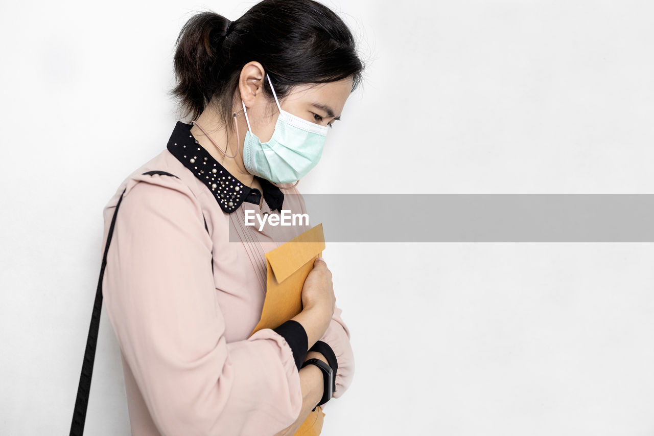 YOUNG WOMAN STANDING ON A WHITE BACKGROUND