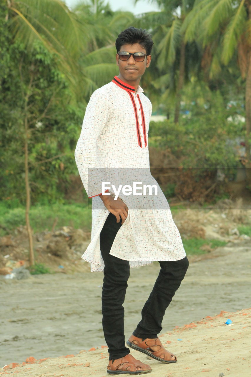 PORTRAIT OF YOUNG MAN STANDING ON STREET