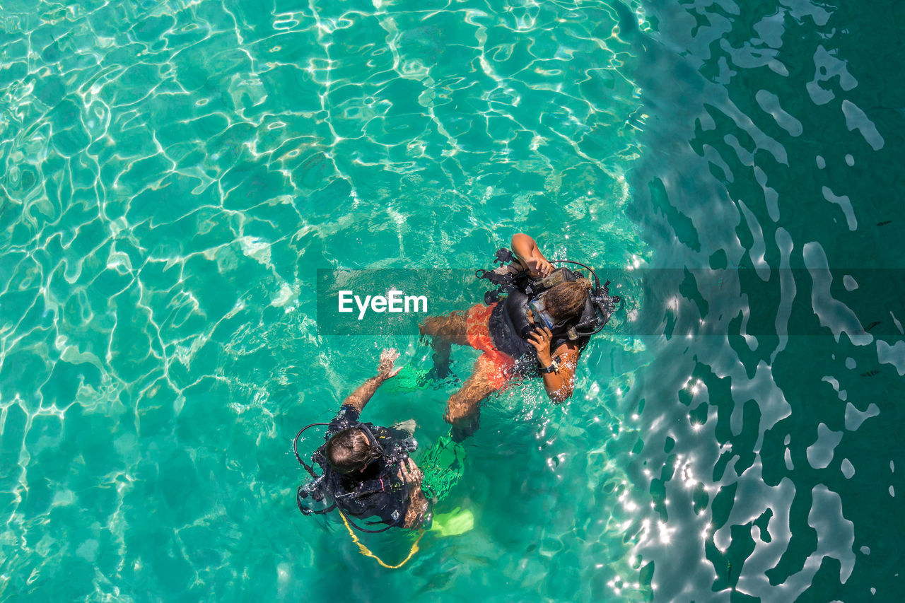 High angle view of friends scuba diving in sea