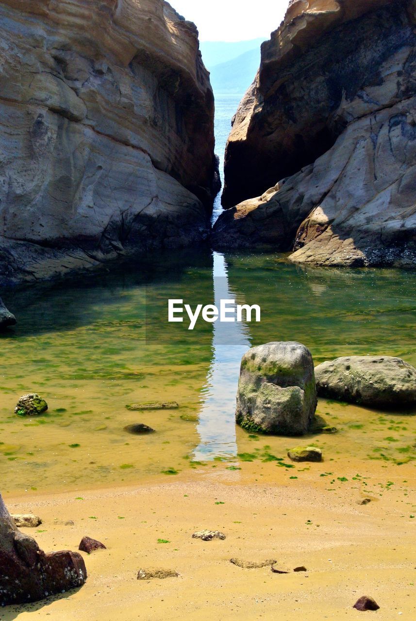 Scenic view of rock formations by beach