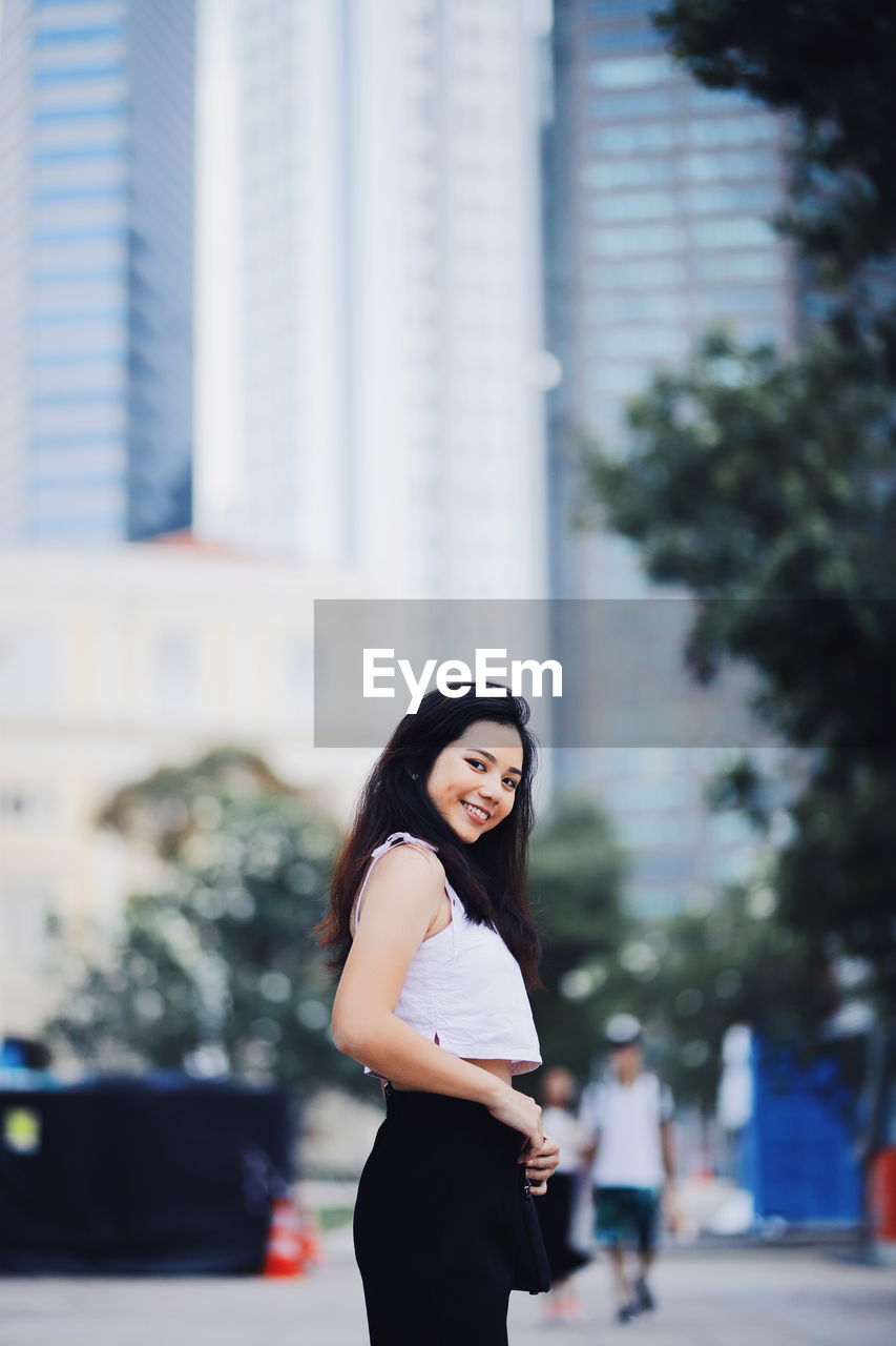 Portrait of woman standing in city