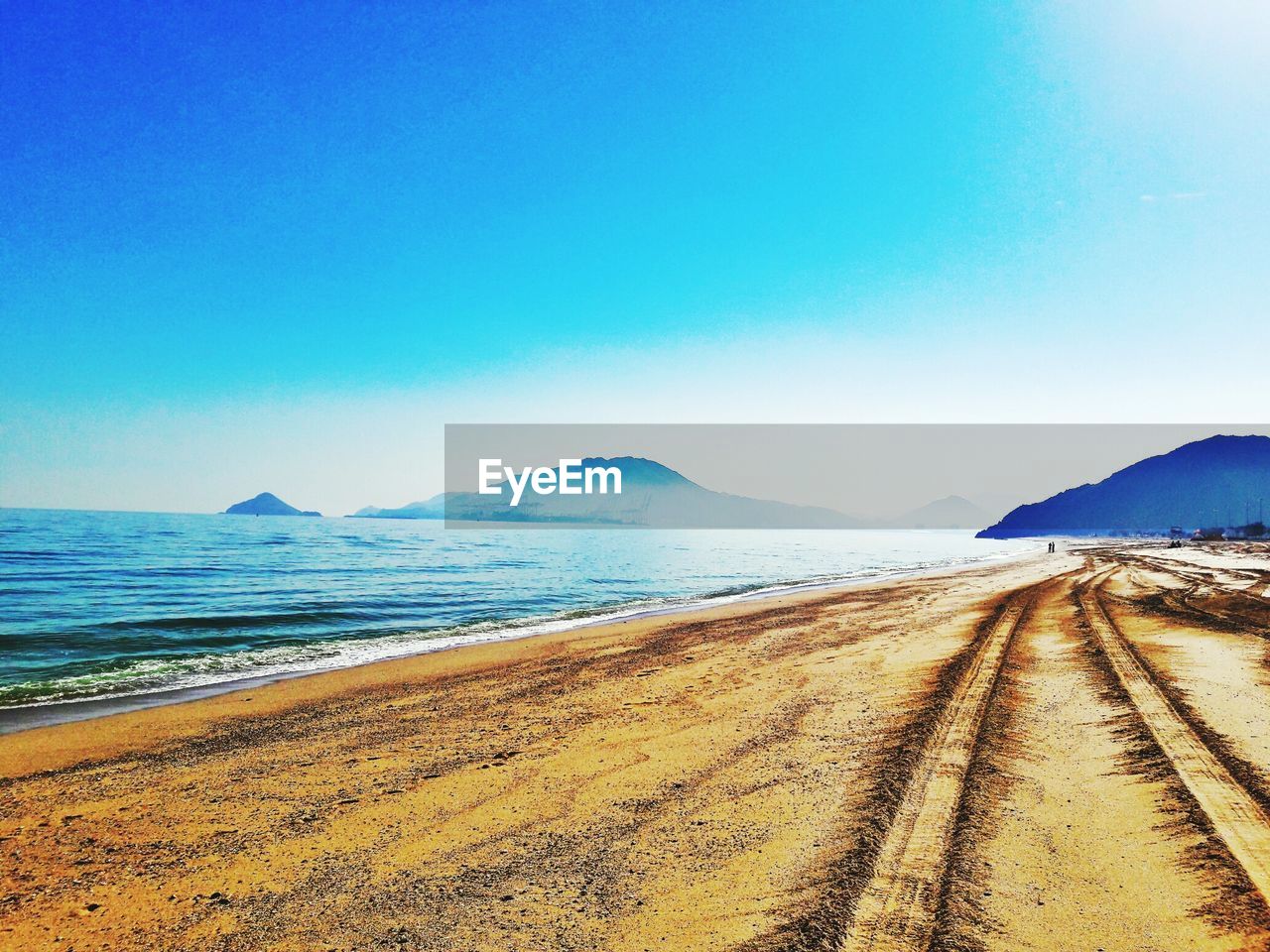 VIEW OF BEACH AGAINST CLEAR BLUE SKY