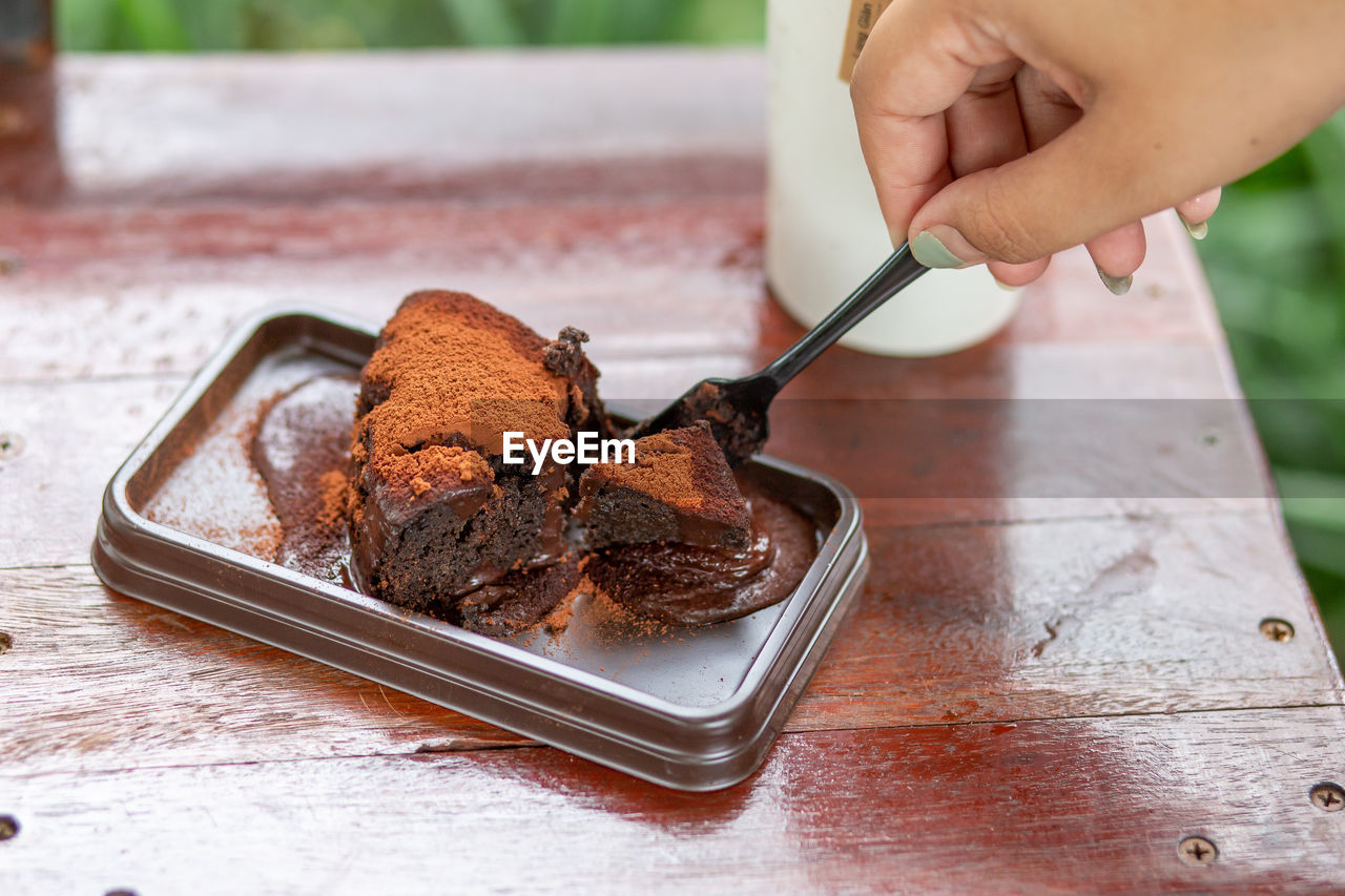 MIDSECTION OF HAND HOLDING ICE CREAM