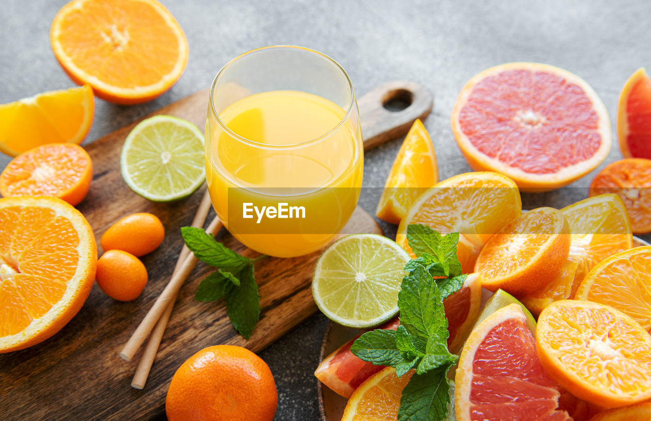 Glass of juice and fresh citrus fruits