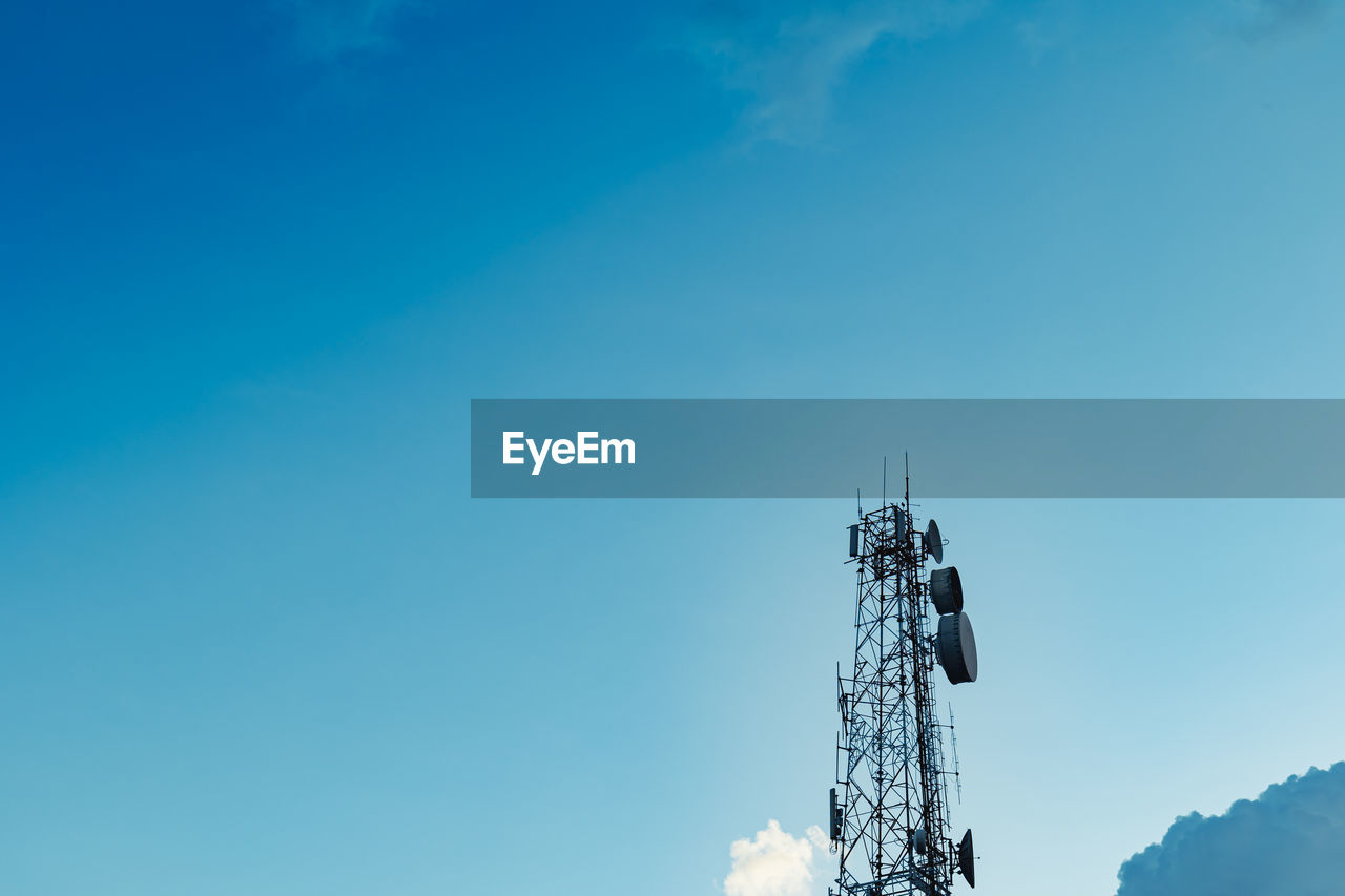 Low angle view of communications tower against blue sky