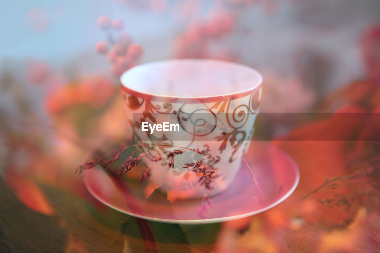 Close-up of cup on table seen through glass