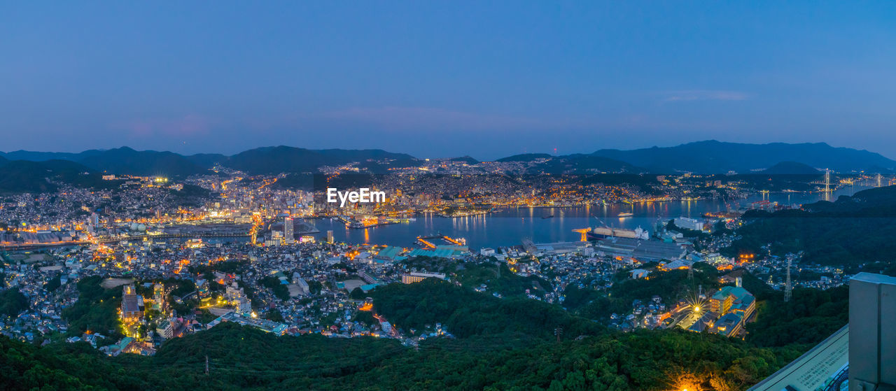 High angle view of city lit up at sunset