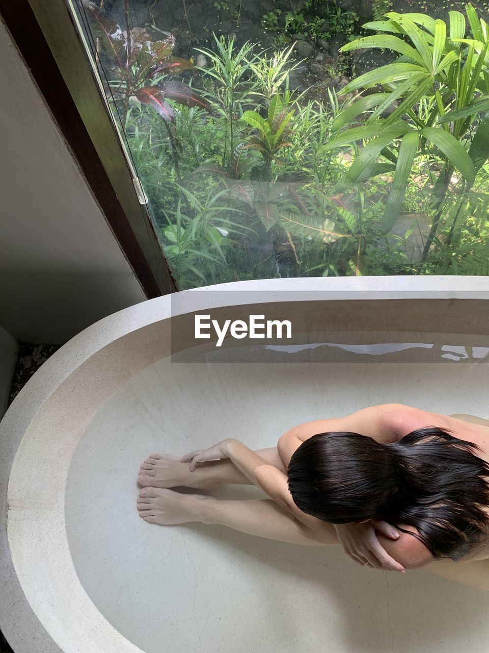 High angle view of woman sitting in bathtub 