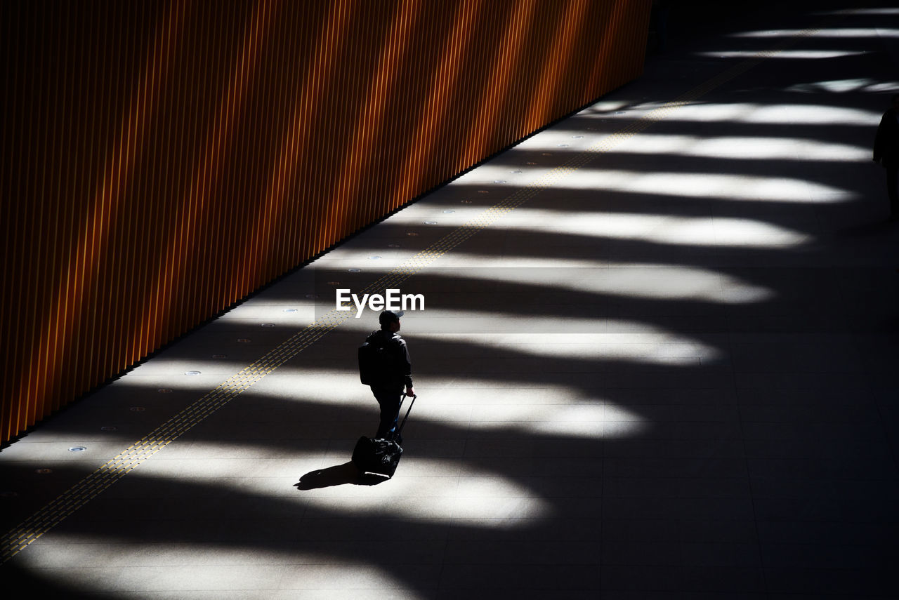 High angle view of silhouette man walking in tunnel