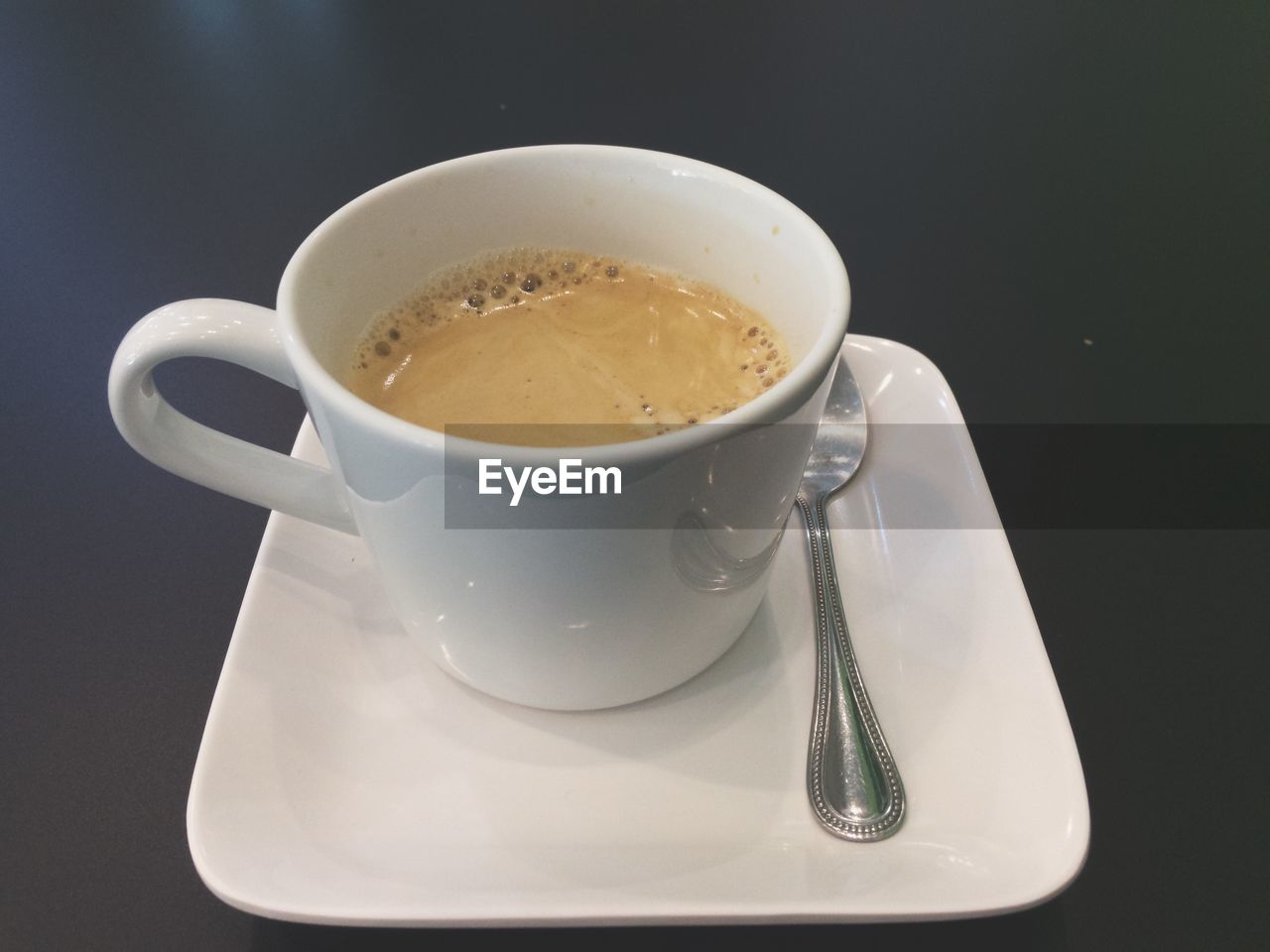 CLOSE-UP OF COFFEE CUP ON BLACK BACKGROUND