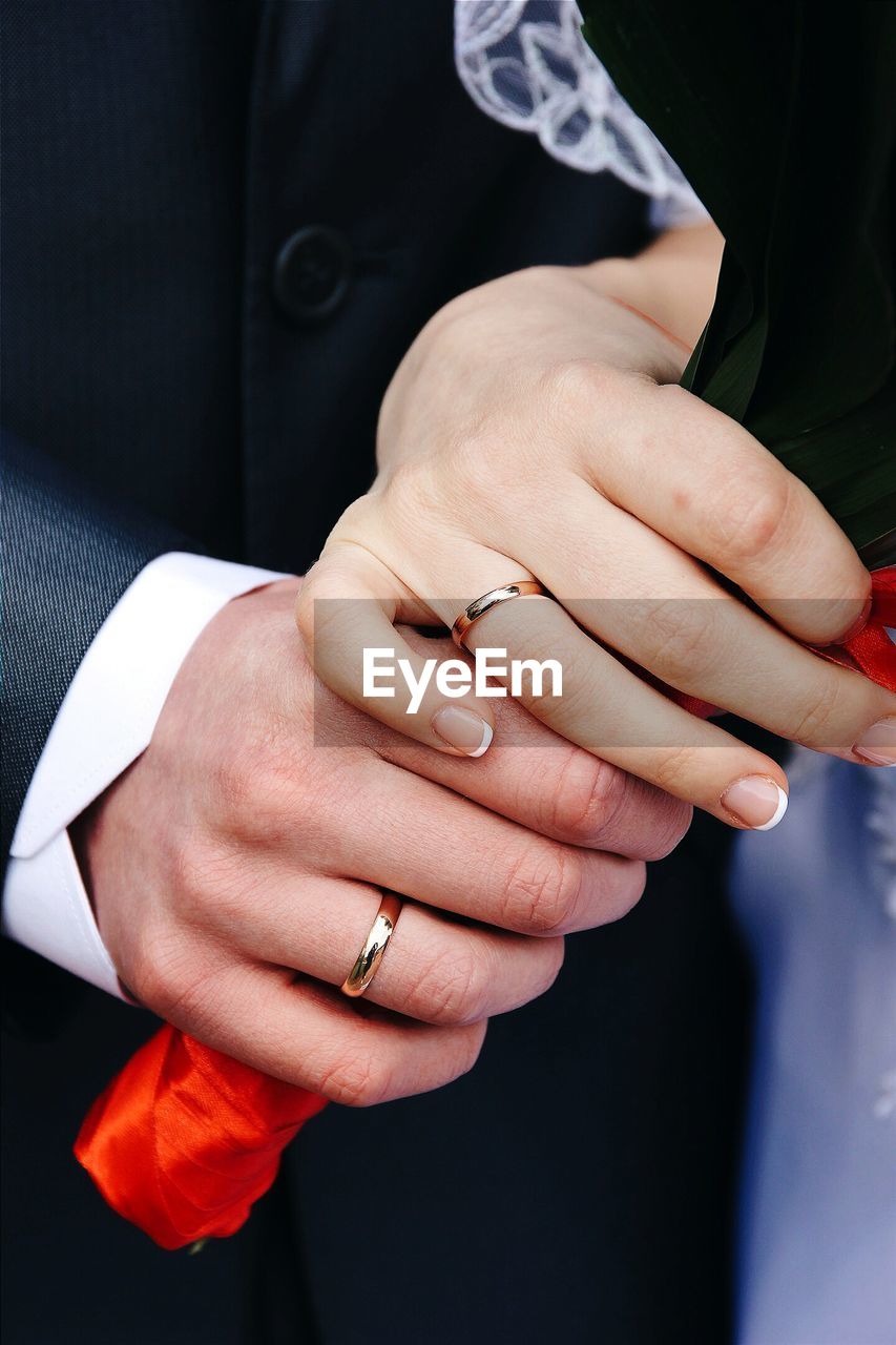 Close-up of bide and groom holding hands during wedding