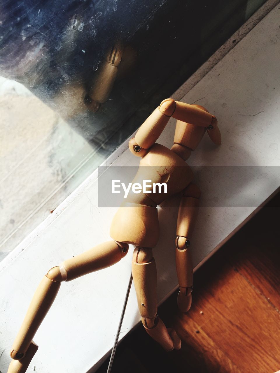 Close-up of wooden doll on window sill