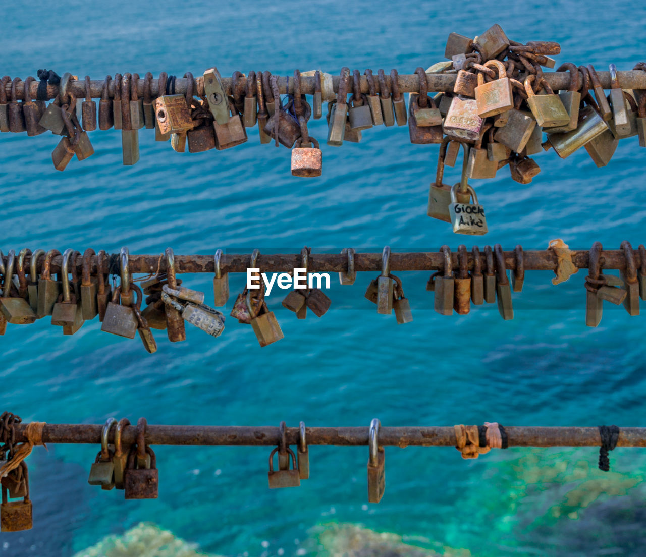 High angle view of padlocks on railing against sea