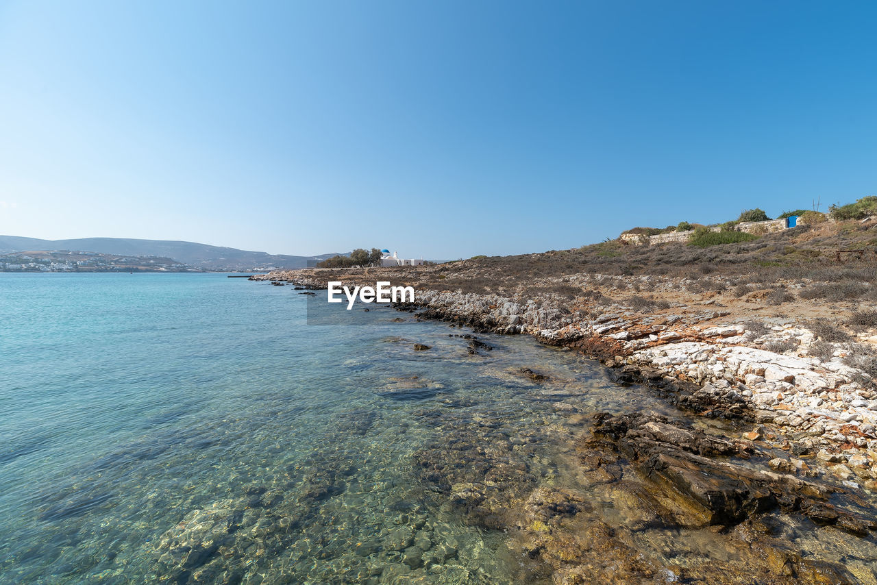 Scenic view of beach against clear blue sky