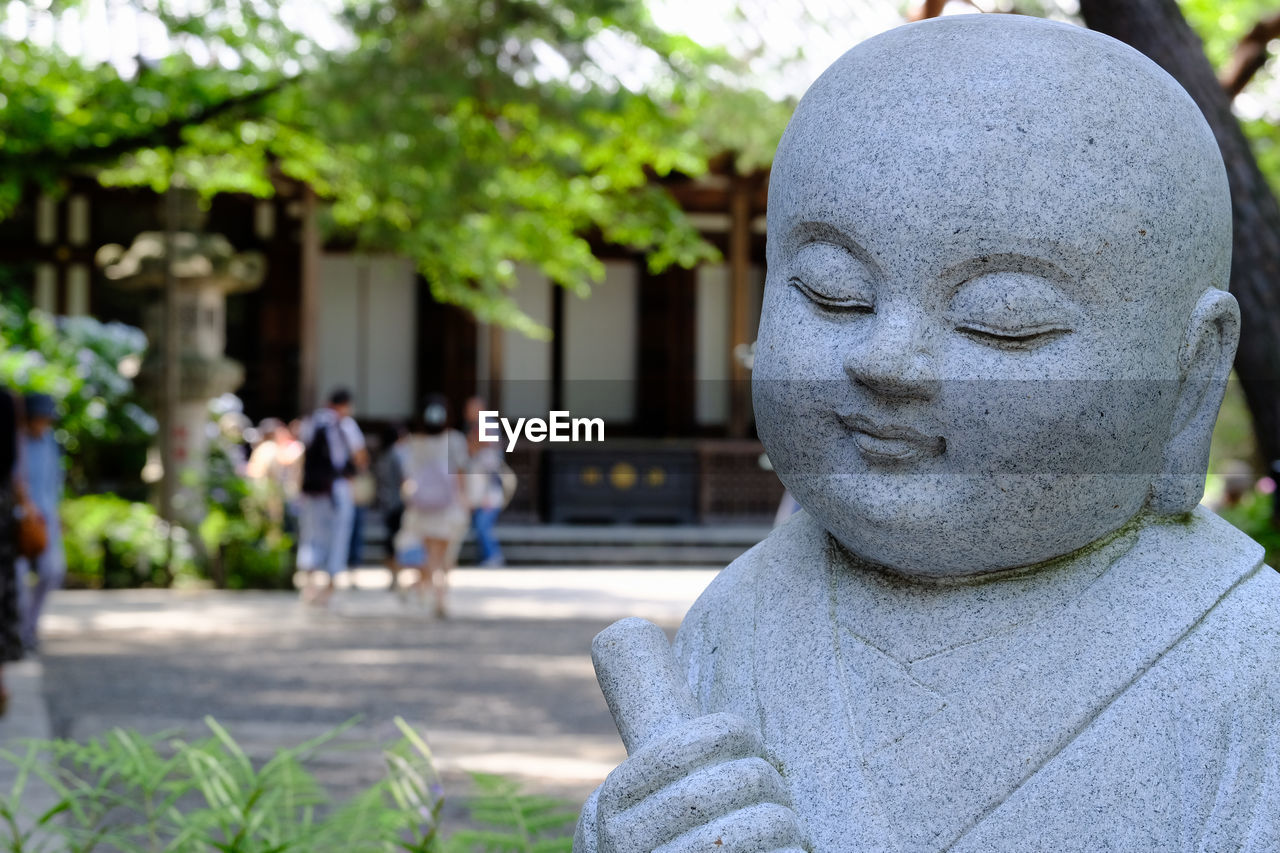 Close-up of statue with people in background