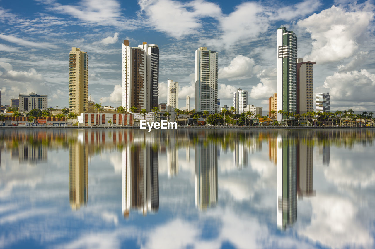 REFLECTION OF BUILDINGS ON LAKE IN CITY