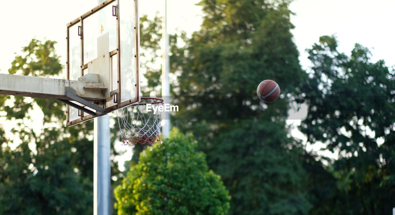 LOW ANGLE VIEW OF BASKETBALL AGAINST SKY