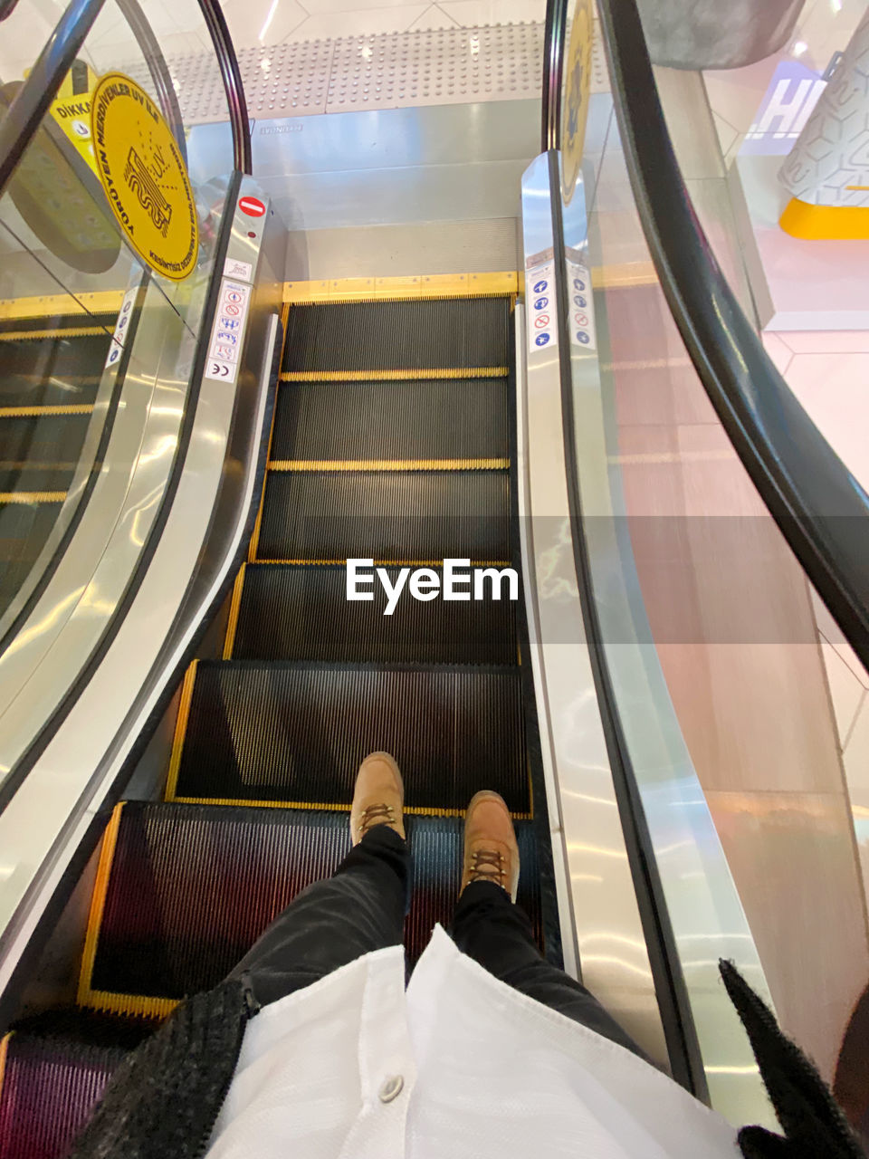 LOW SECTION OF MAN ON ESCALATOR IN OFFICE