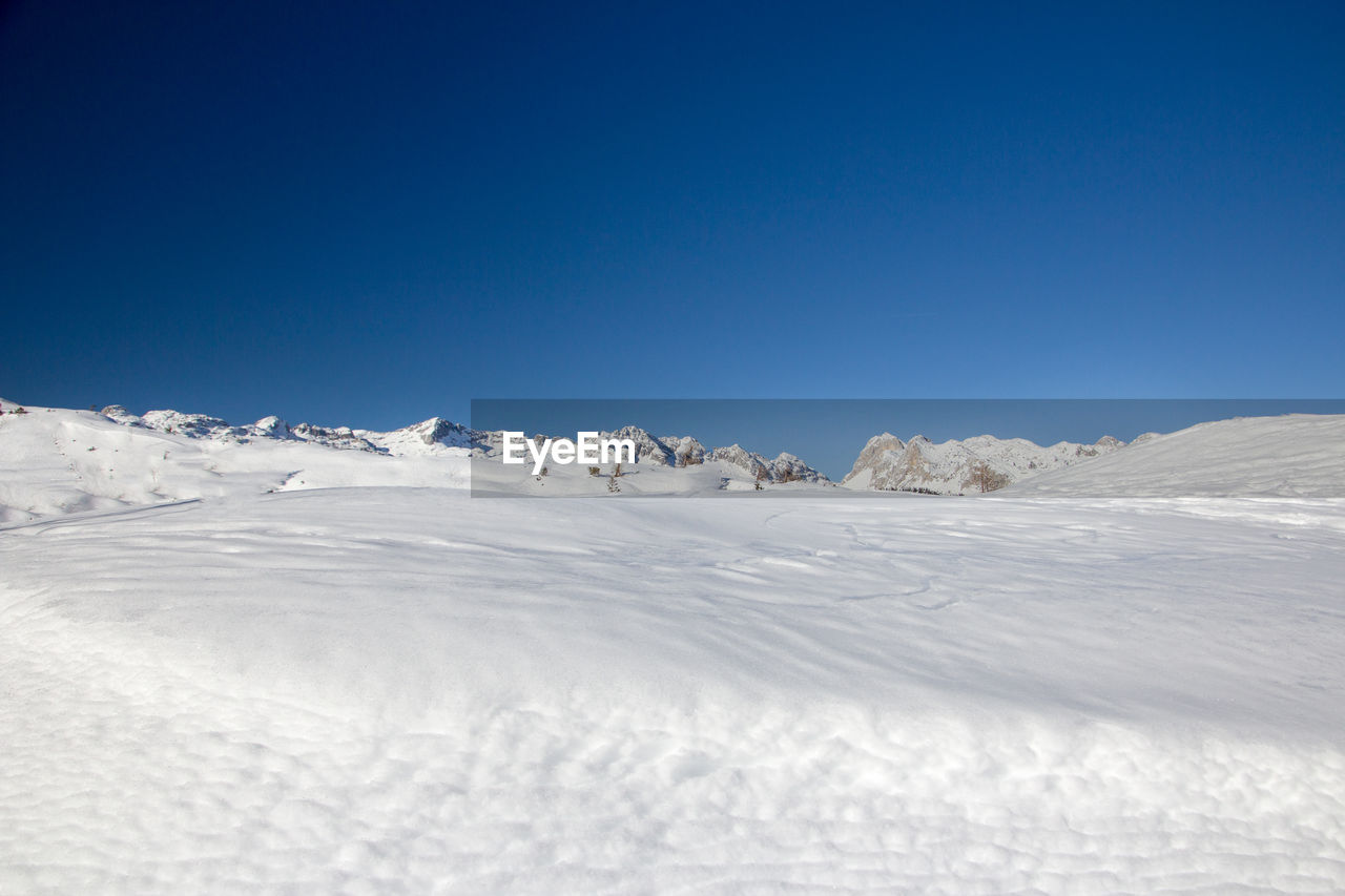 Scenic view of snowcapped mountains against clear blue sky