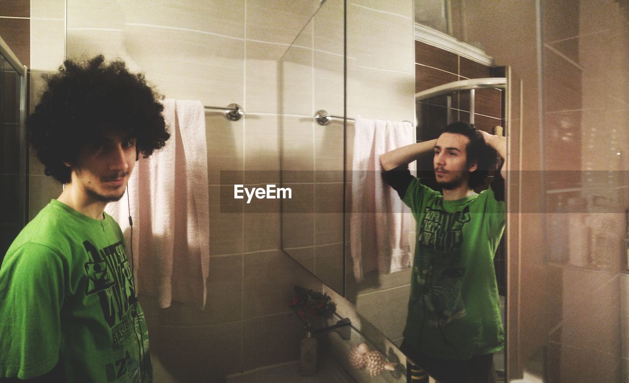 PORTRAIT OF YOUNG MAN IN BATHROOM