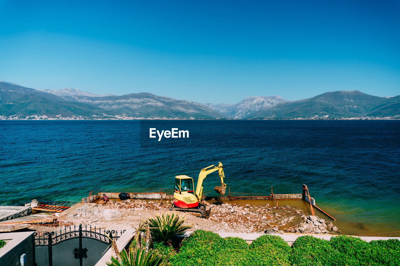 VIEW OF SEA AGAINST MOUNTAIN