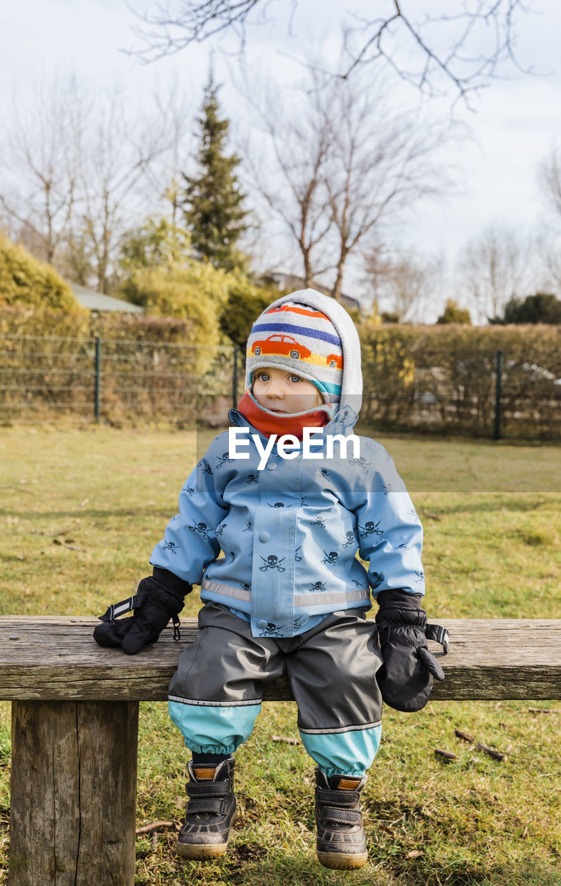 Girl sitting on bench during winter