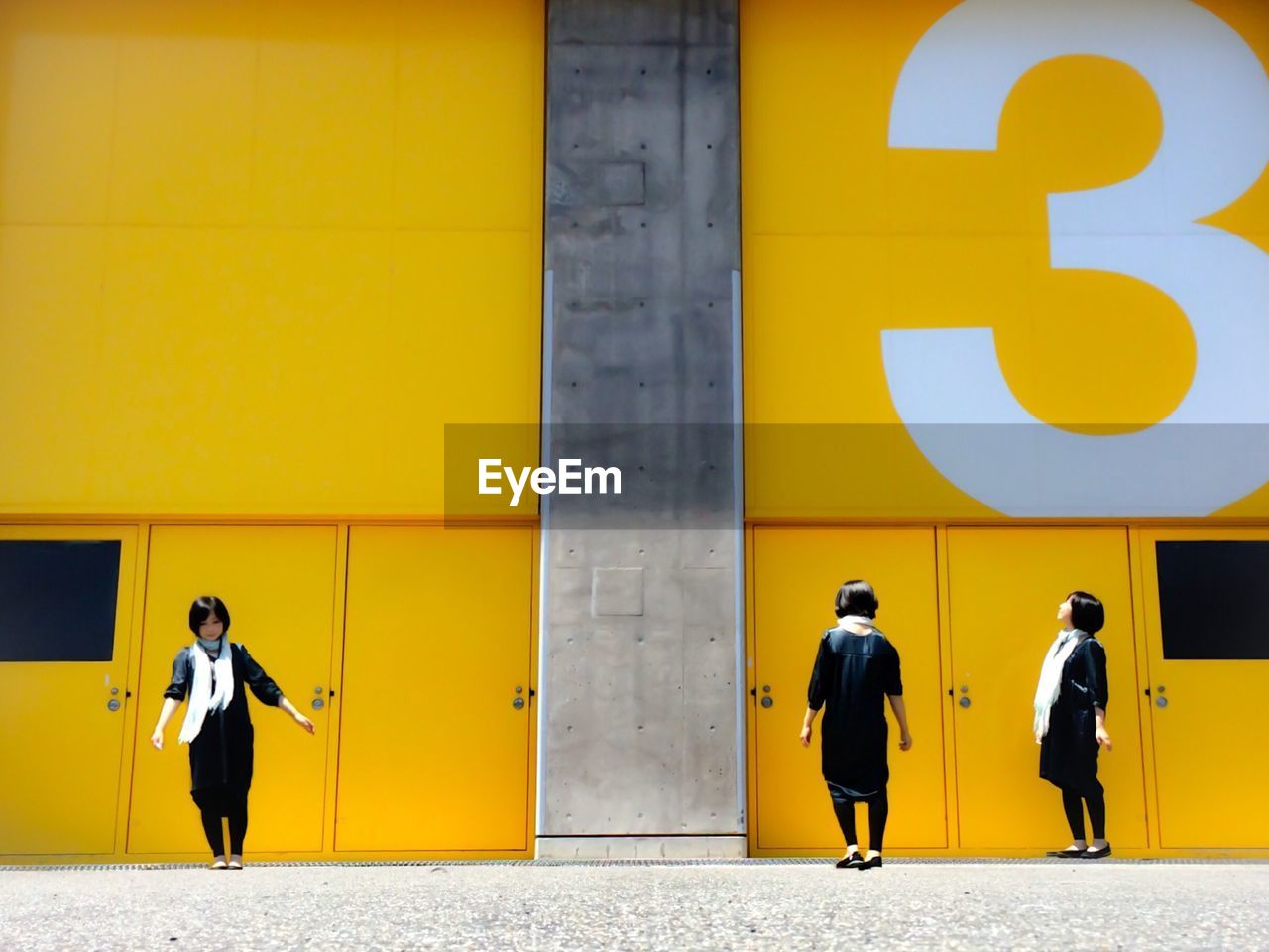 FULL LENGTH REAR VIEW OF MAN WALKING IN YELLOW BUILDING