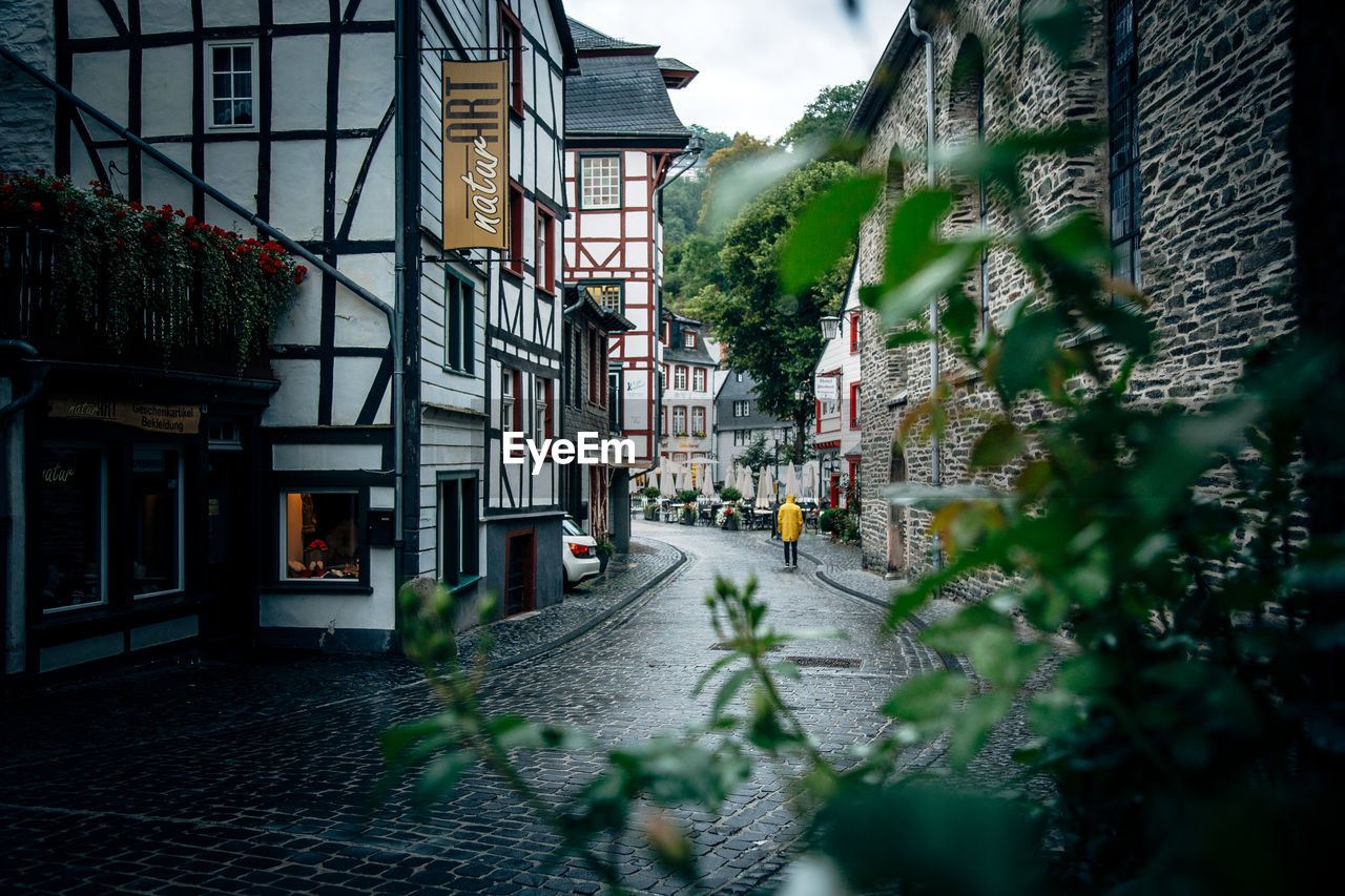 STREET BY BUILDINGS AGAINST SKY