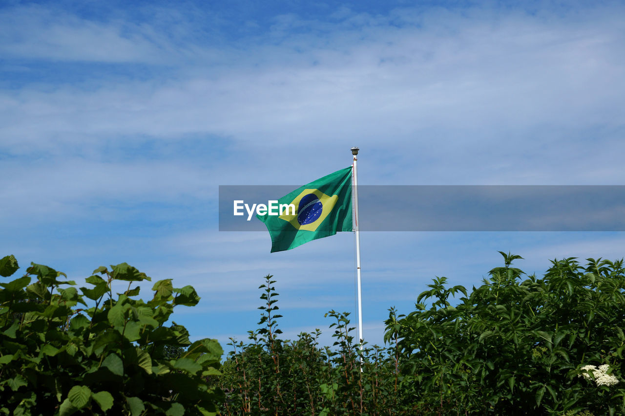 Low angle view of brazilian flag against blue sky