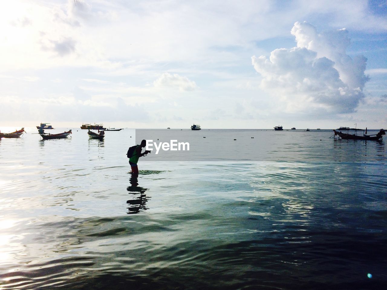 Side view of man photographing in sea