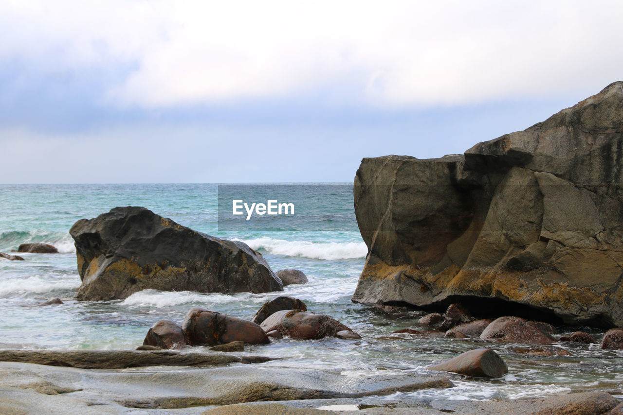 Rocks on beach against sky