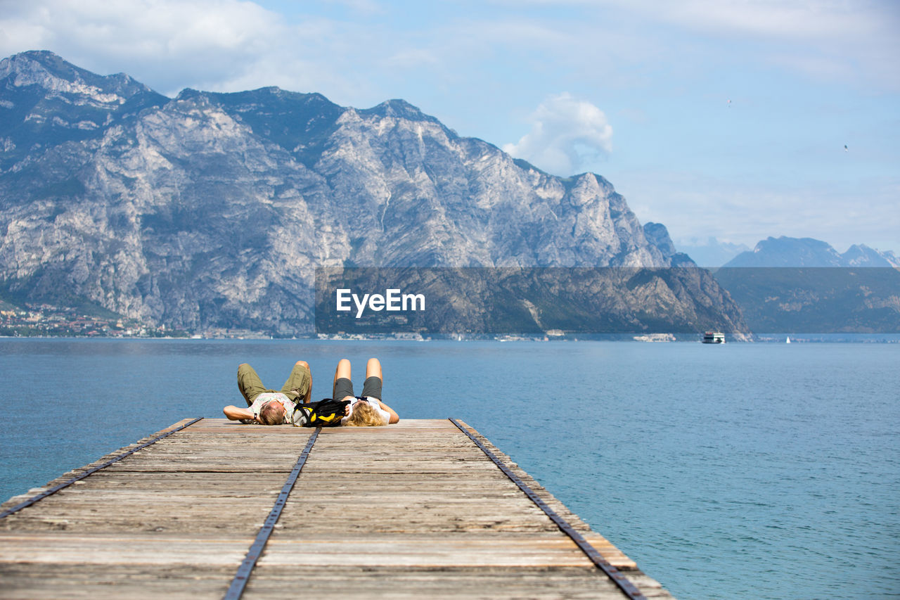 MEN FISHING IN LAKE AGAINST SKY