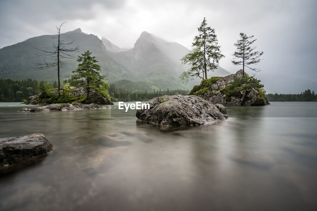 View of rocks in water against sky