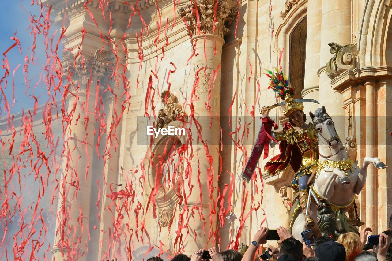 Red streamers falling to crowd in front of palace