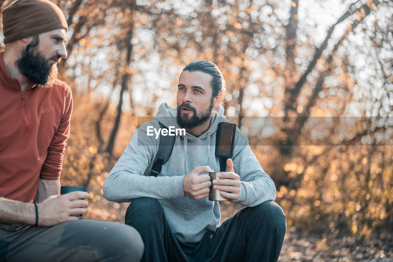 YOUNG MAN SITTING ON TREE