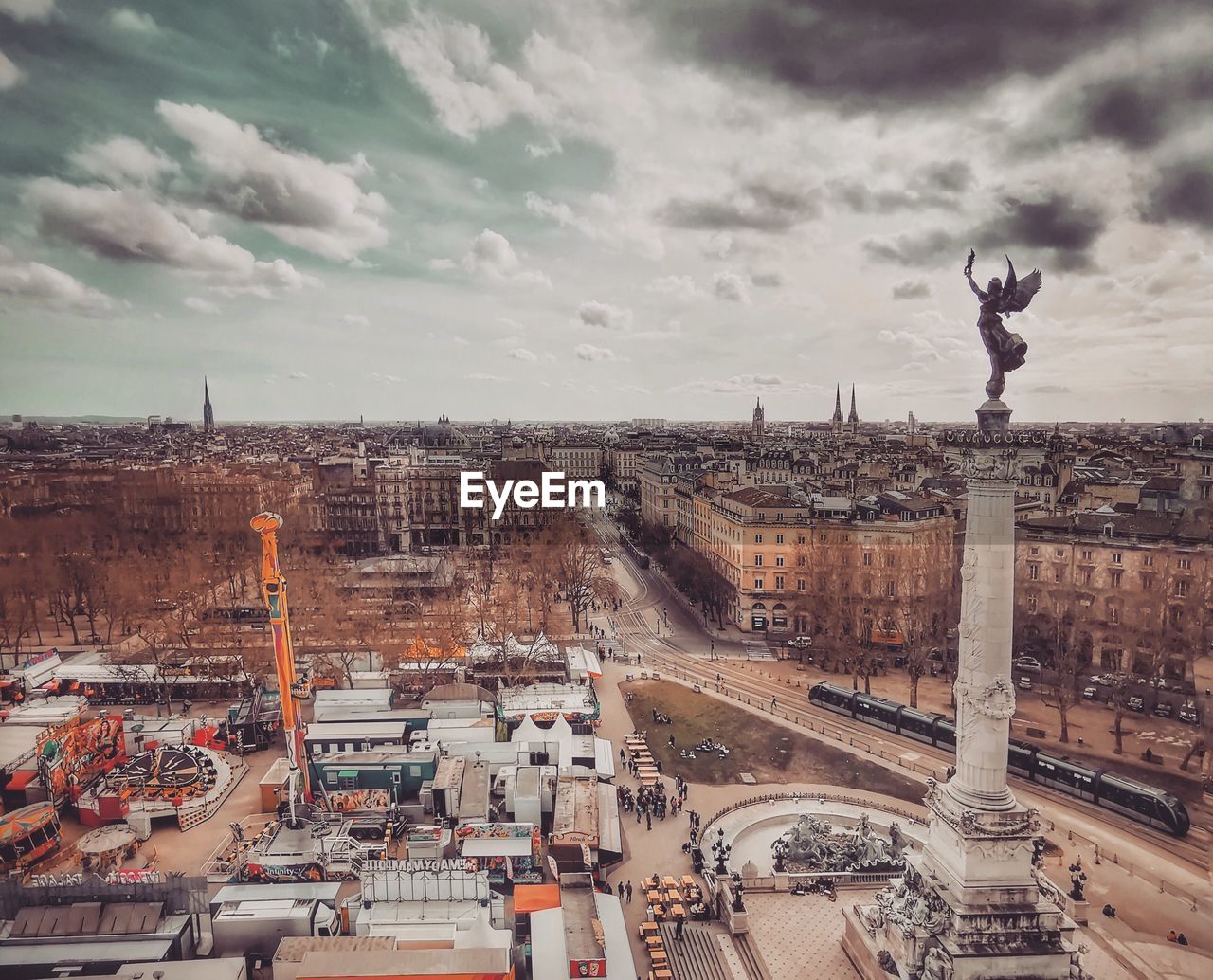 High angle view of city buildings against cloudy sky