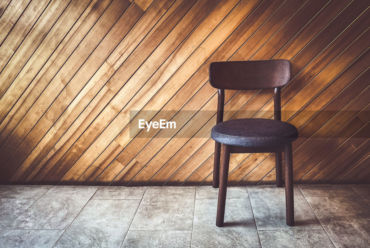 Empty chair on table against wall