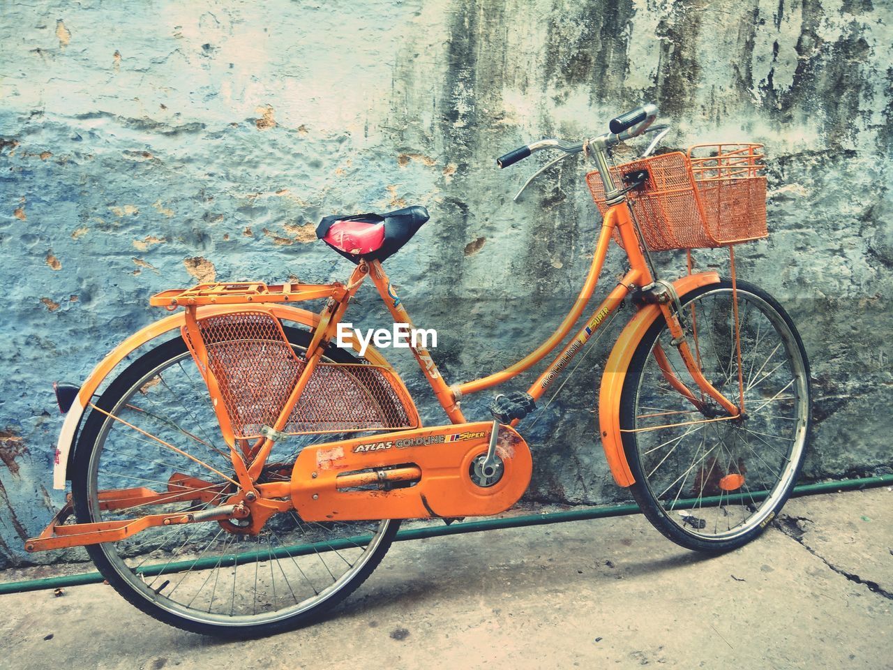 BICYCLE PARKED BY WALL