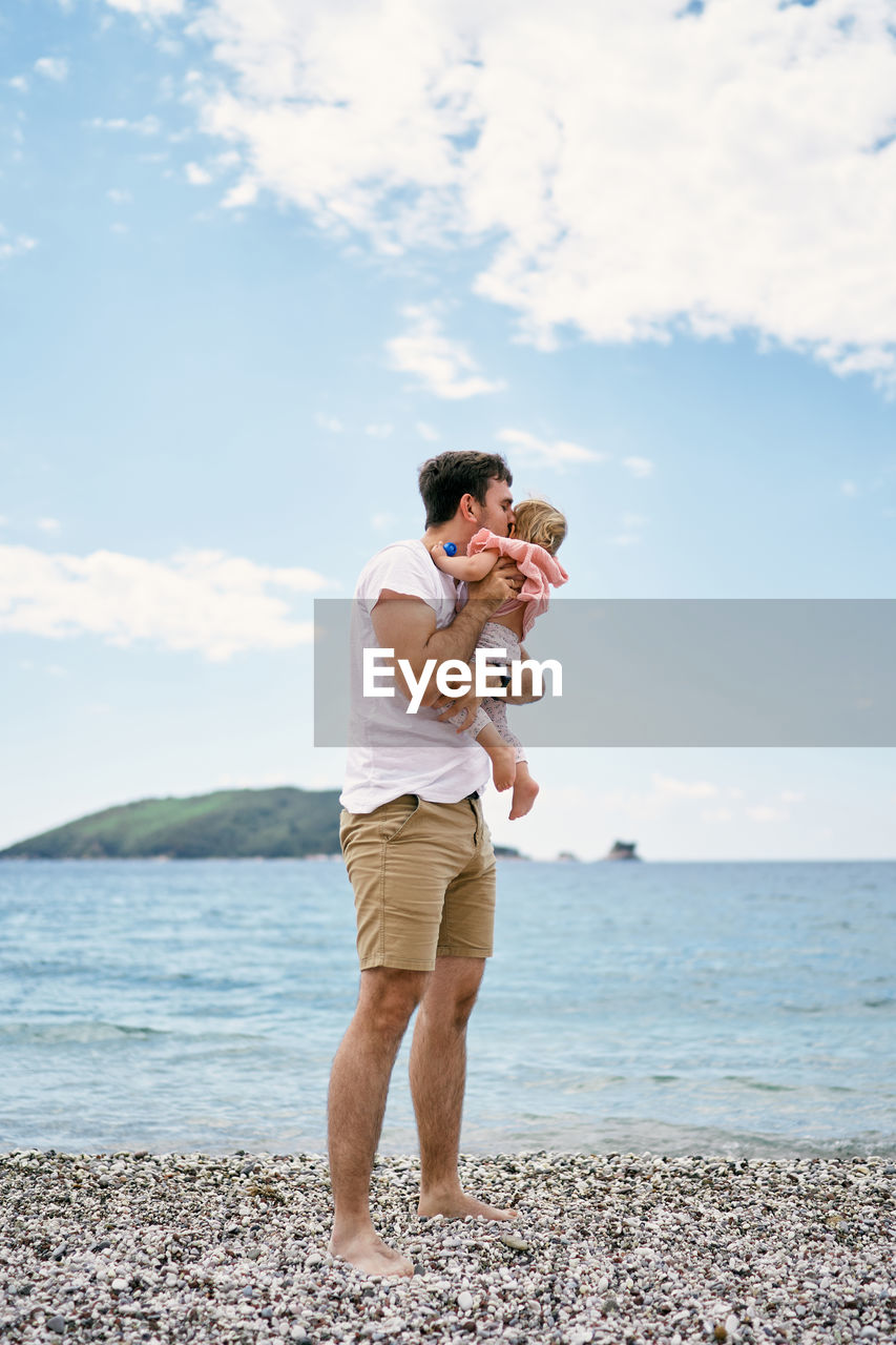 Full length of man standing on beach against sky