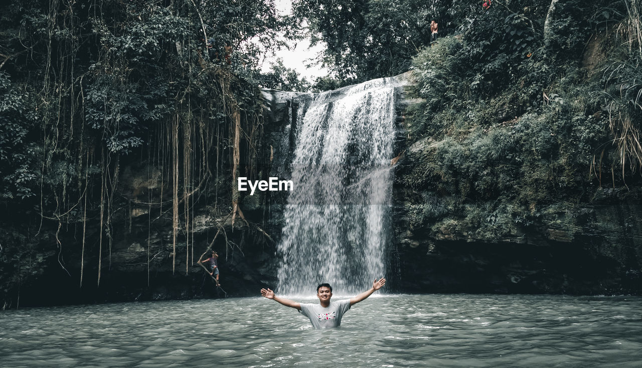 Man surfing on waterfall in forest