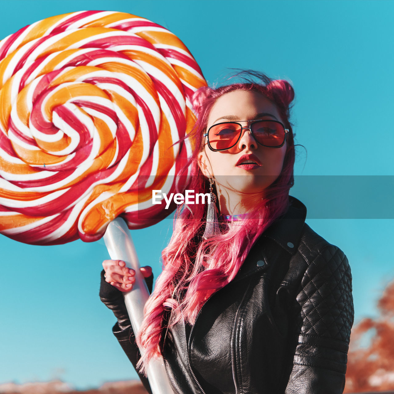 Portrait of beautiful woman holding artificial lollipop