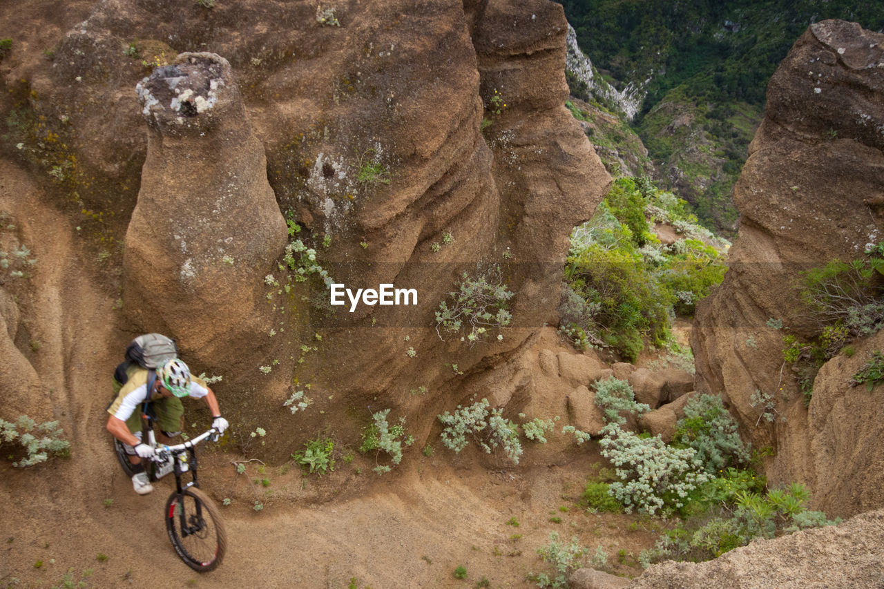 High angle view of man mountain biking on rock formation