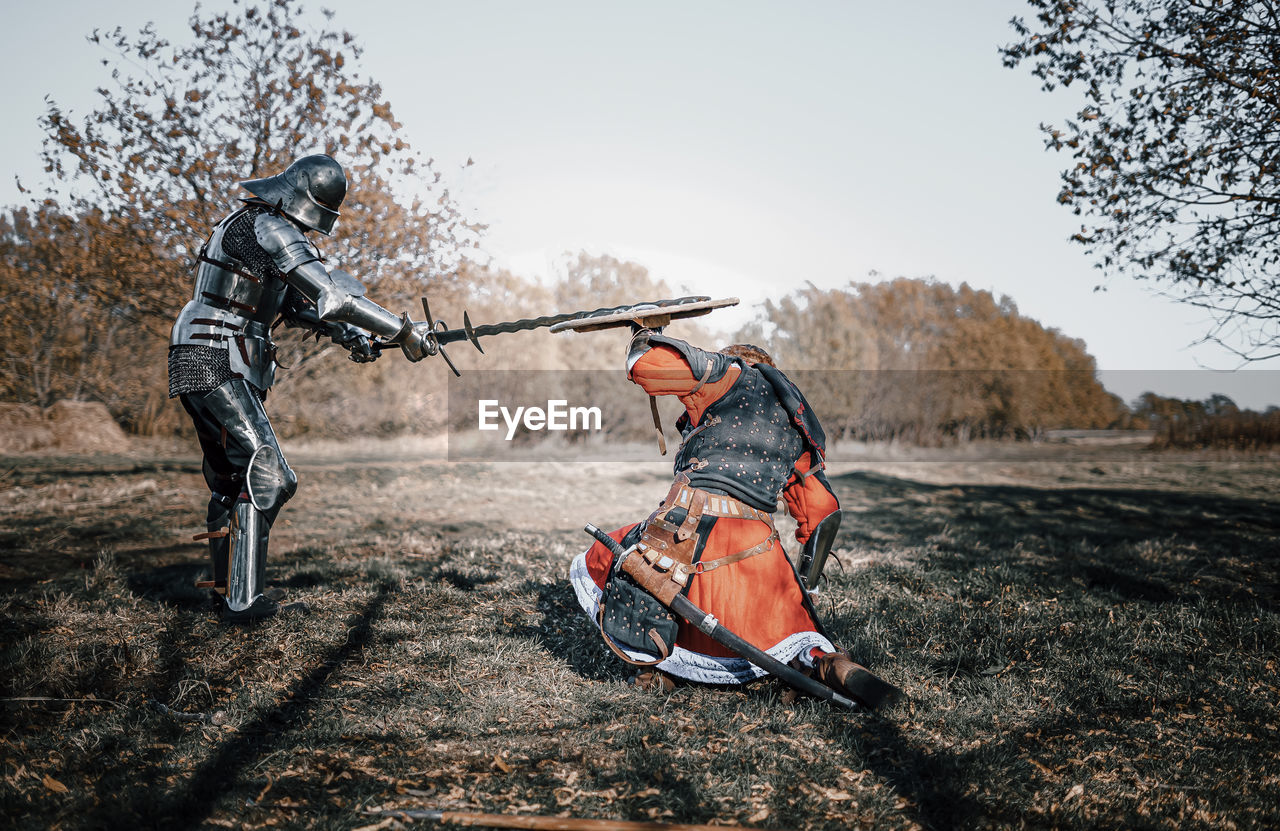 Full length of warriors fighting on field